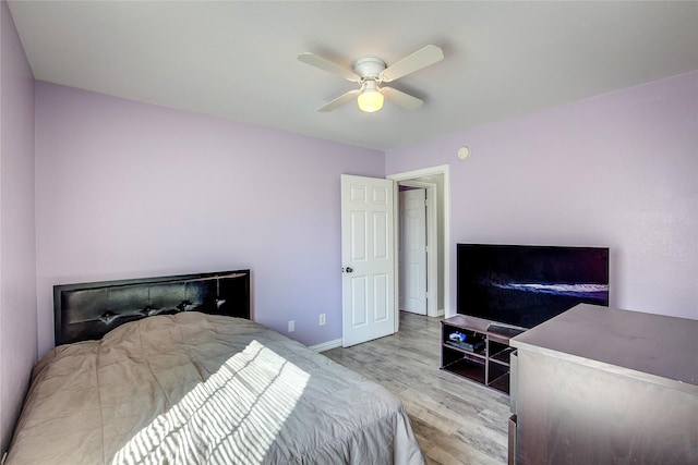 bedroom with ceiling fan, baseboards, and wood finished floors