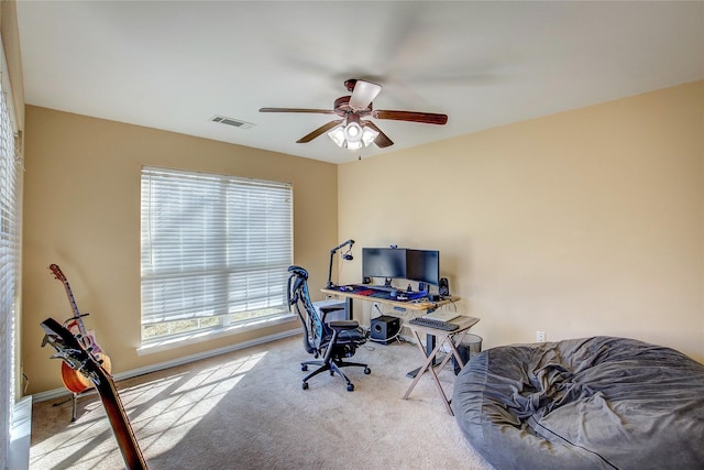 carpeted office space featuring a ceiling fan, visible vents, and baseboards