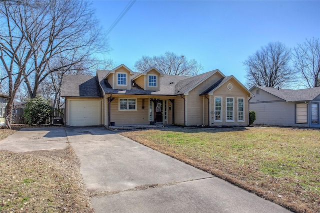 view of front of house with roof with shingles, a front yard, fence, a garage, and driveway