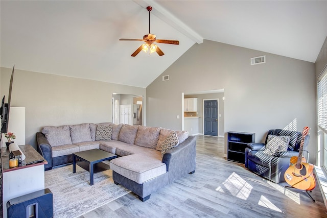 living room with beamed ceiling, visible vents, and light wood-style floors