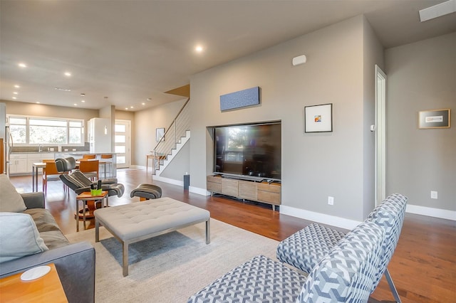 living room with baseboards, stairway, wood finished floors, and recessed lighting