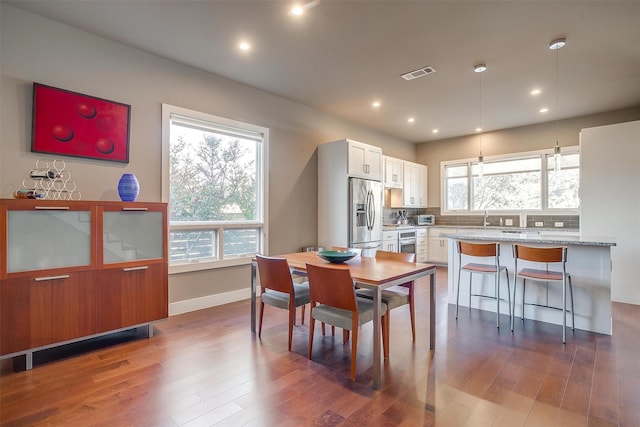 dining area with baseboards, visible vents, wood finished floors, and recessed lighting