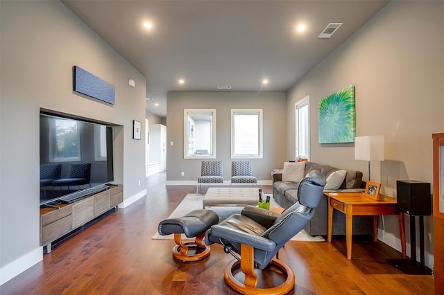 living area featuring dark wood-style floors, baseboards, visible vents, and recessed lighting