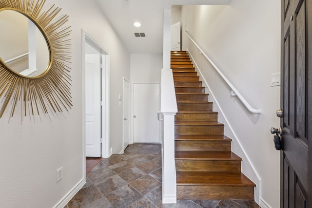 stairs featuring recessed lighting, visible vents, baseboards, and stone finish floor