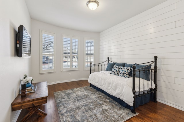 bedroom featuring dark wood-style flooring and baseboards