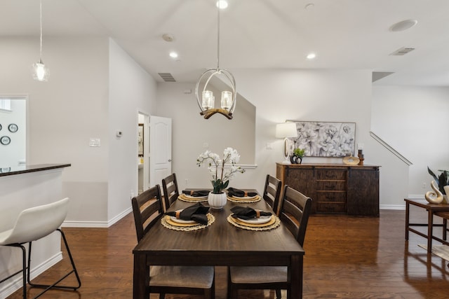 dining space featuring a notable chandelier, baseboards, visible vents, and wood finished floors