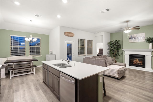 kitchen with visible vents, open floor plan, hanging light fixtures, light countertops, and a sink