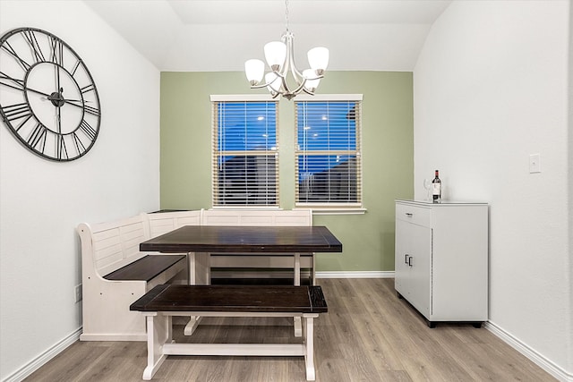 dining area featuring light wood finished floors, baseboards, and a chandelier