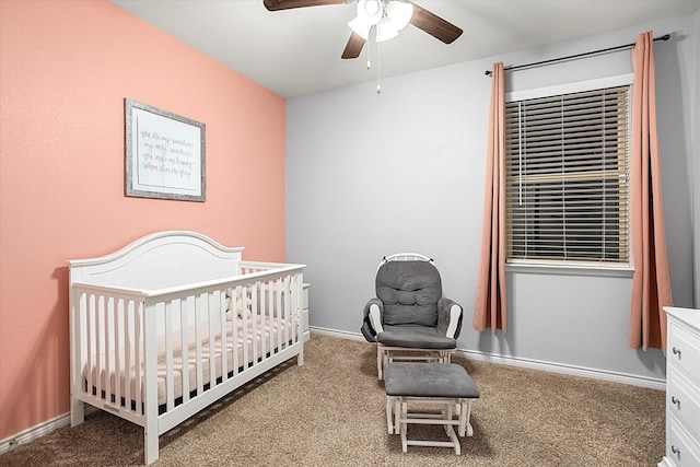 carpeted bedroom with a nursery area, ceiling fan, and baseboards