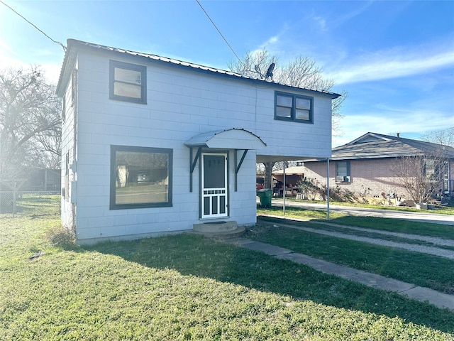 view of front of home with a carport, entry steps, metal roof, and a front lawn