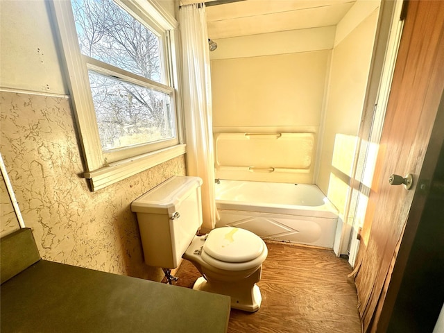 bathroom featuring wood finished floors, toilet, and wallpapered walls