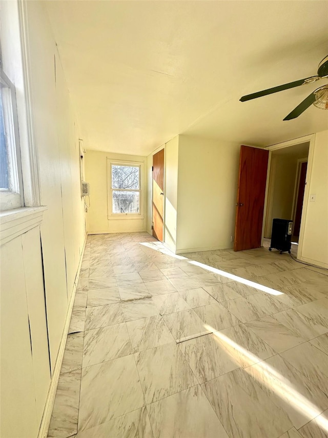 empty room featuring marble finish floor and a ceiling fan