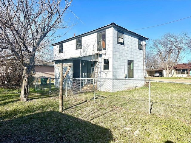 back of property with fence and a lawn