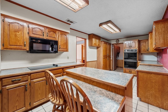 kitchen featuring visible vents, brown cabinets, light countertops, a textured ceiling, and black appliances