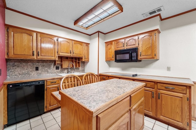 kitchen with light countertops, visible vents, decorative backsplash, a kitchen island, and black appliances