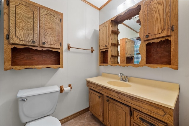 bathroom featuring crown molding, toilet, vanity, baseboards, and tile patterned floors