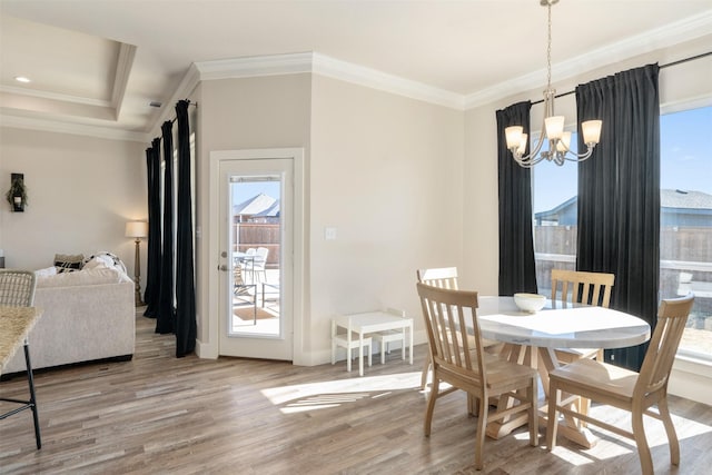 dining space featuring baseboards, crown molding, an inviting chandelier, and wood finished floors