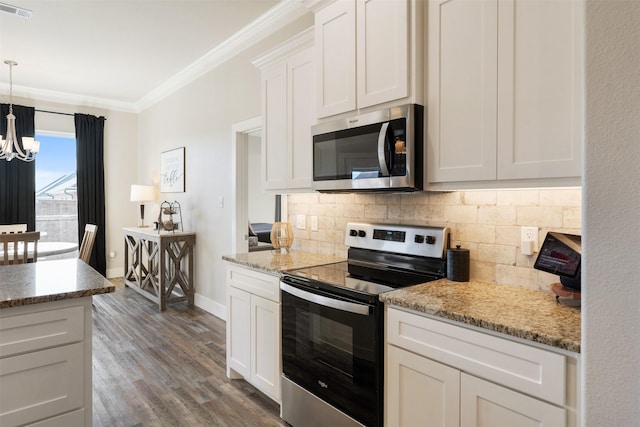 kitchen with visible vents, appliances with stainless steel finishes, hanging light fixtures, crown molding, and white cabinetry