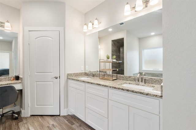 full bath featuring double vanity, wood finished floors, a closet, and a sink