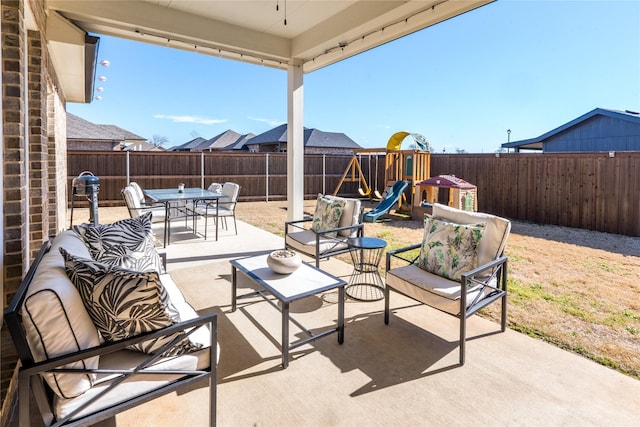 view of patio / terrace with a fenced backyard, outdoor dining area, a playground, and an outdoor living space