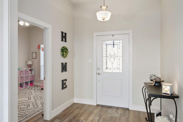 foyer with wood finished floors and baseboards