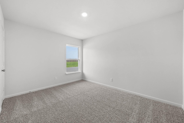 empty room featuring carpet floors and baseboards