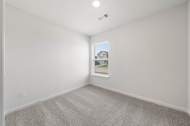 carpeted spare room featuring visible vents and baseboards