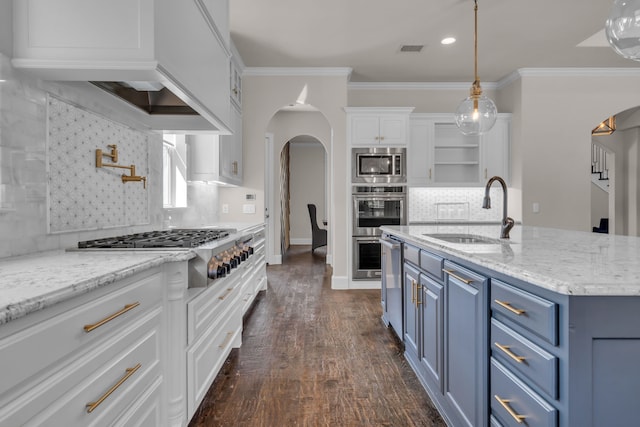 kitchen featuring arched walkways, blue cabinets, a sink, visible vents, and appliances with stainless steel finishes