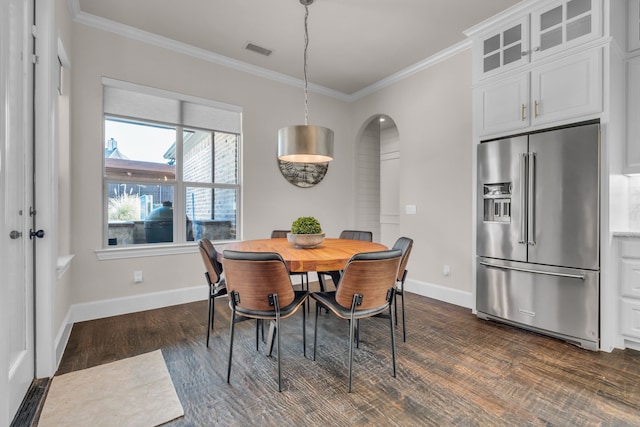 dining area with dark wood finished floors, visible vents, crown molding, and baseboards