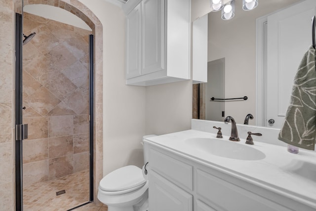 bathroom with toilet, a stall shower, and vanity