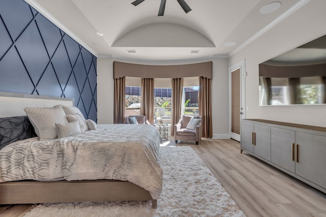 bedroom featuring light wood-type flooring, access to exterior, a tray ceiling, and ornamental molding