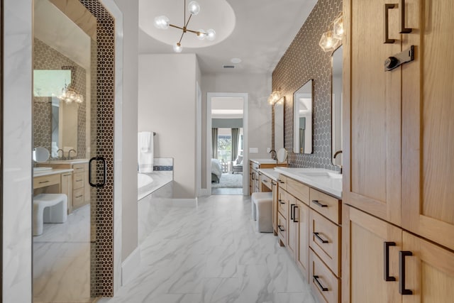 bathroom with visible vents, marble finish floor, a garden tub, vanity, and a chandelier