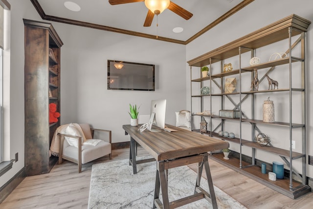 office space featuring ornamental molding, baseboards, ceiling fan, and light wood finished floors