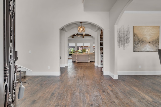 entrance foyer with baseboards, arched walkways, hardwood / wood-style floors, and ornamental molding