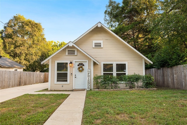 bungalow with fence and a front lawn