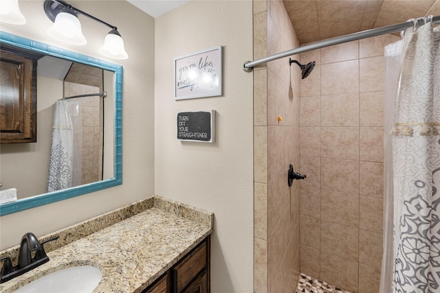 full bath with tiled shower and vanity