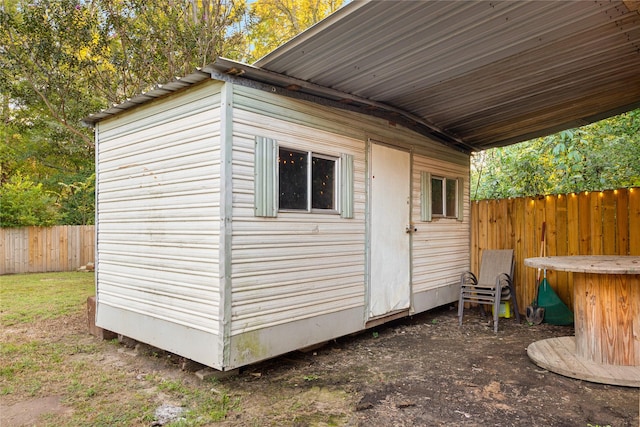 view of outbuilding featuring fence and an outdoor structure