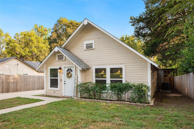 bungalow-style house featuring roof with shingles, a patio, a front yard, central AC, and fence