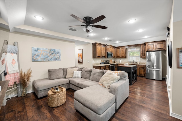 living room with visible vents, dark wood-type flooring, and recessed lighting