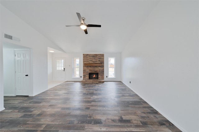 unfurnished living room with ceiling fan, high vaulted ceiling, wood finished floors, visible vents, and a brick fireplace