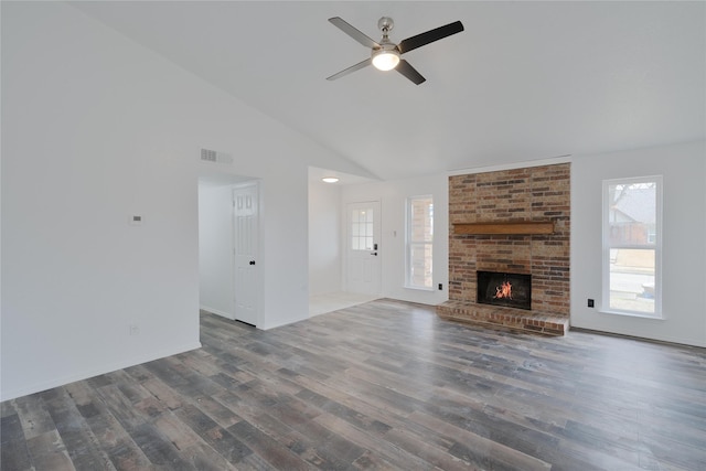 unfurnished living room with plenty of natural light, a fireplace, visible vents, and wood finished floors