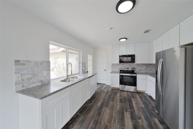 kitchen featuring dark wood-style flooring, appliances with stainless steel finishes, backsplash, and a sink