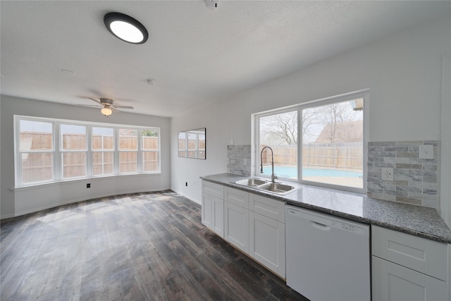 kitchen with dishwasher, decorative backsplash, a sink, and dark wood-style floors