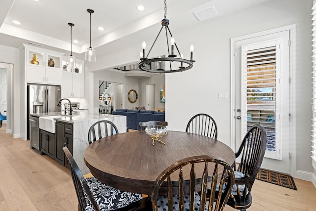 dining space featuring recessed lighting, visible vents, baseboards, light wood-style floors, and a tray ceiling