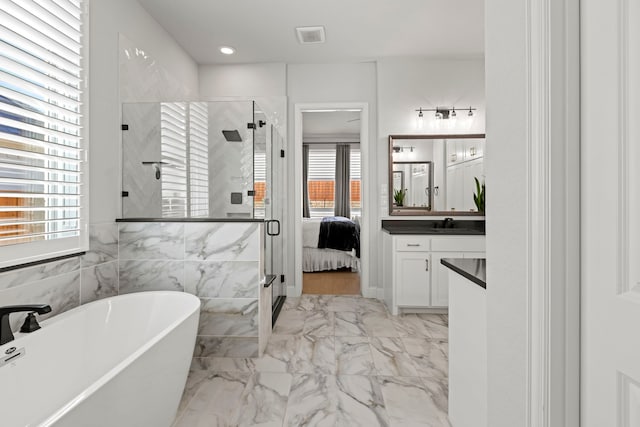 bathroom featuring a stall shower, visible vents, a soaking tub, marble finish floor, and vanity