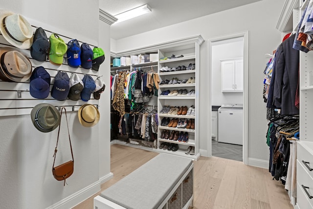 walk in closet featuring light wood finished floors and independent washer and dryer