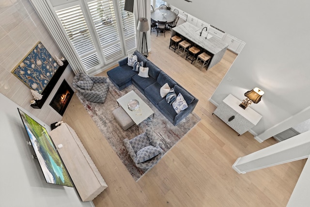 living area with a warm lit fireplace and wood finished floors