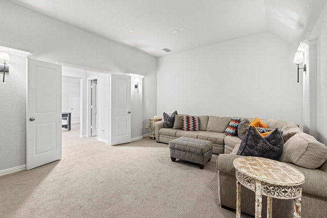 living area featuring lofted ceiling, baseboards, visible vents, and light colored carpet