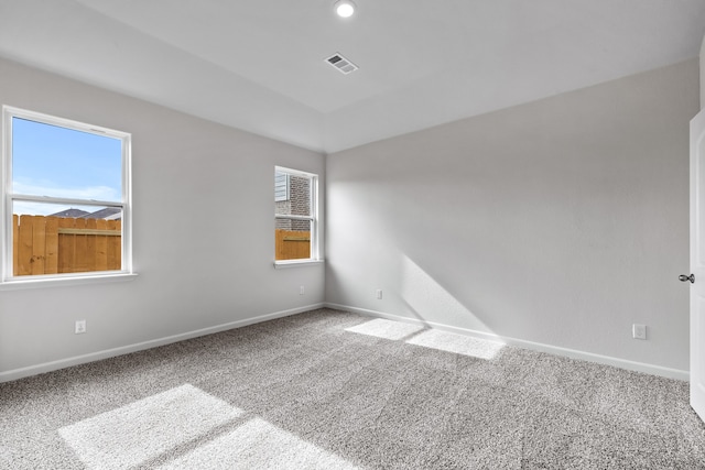 carpeted spare room with baseboards and visible vents