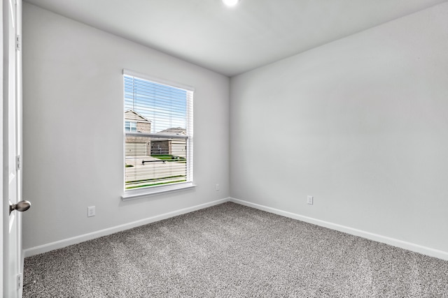 empty room featuring baseboards and carpet flooring